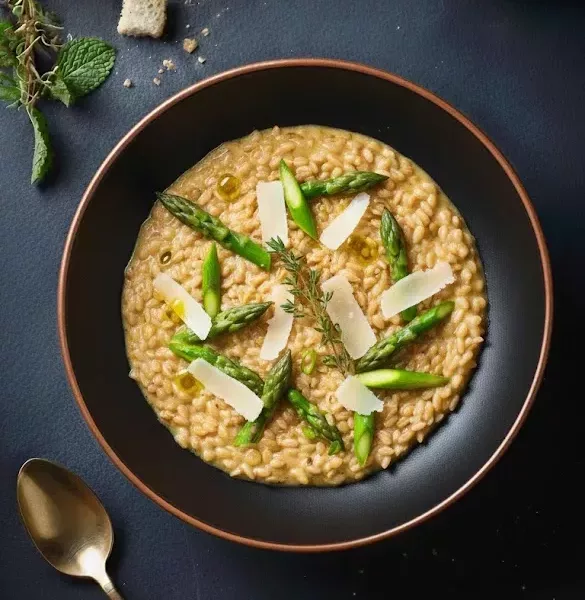 Risotto crémeux d’épeautre, mêlé à des asperges vertes croquantes et parsemé de vieux comté râpé.