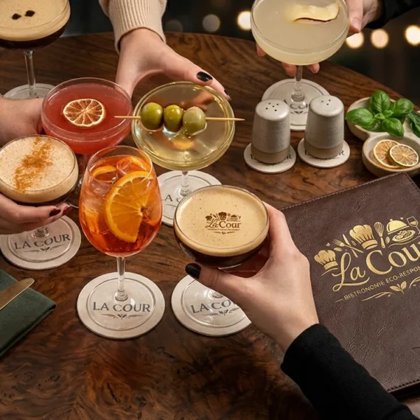 Participants réalisant des cocktails lors d’un atelier encadré, avec des verres, des fruits et des ustensiles de bar.